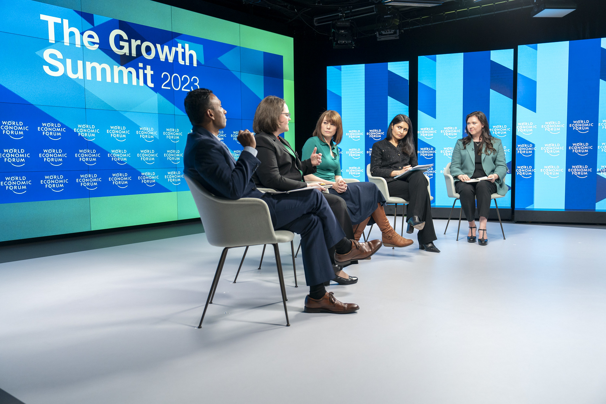 A group of people sitting in chairs on stage in discussion